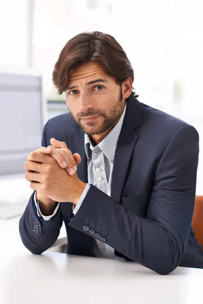 Succes en niets minder. Portret van een knappe man aan een bureau in een kantoor. — Stockfoto