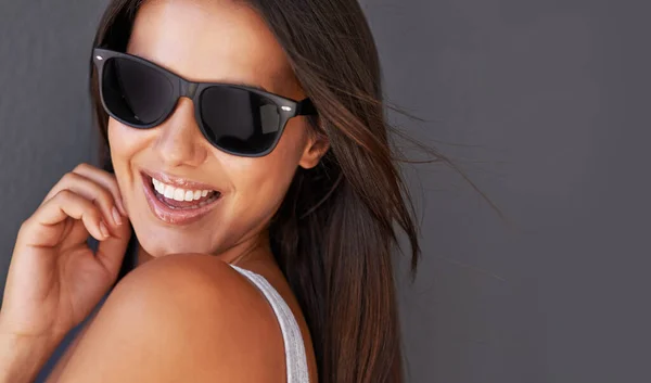 Brimming with confidence. Shot of a beautiful young woman wearing sunglasses. — Stock Photo, Image