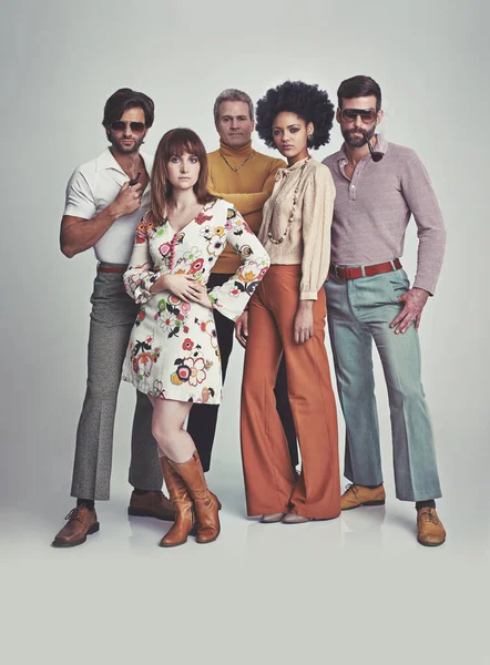 Nie ma to jak styl lat 70-tych. Studyjne ujęcie grupy ludzi stojących razem, ubranych w retro lat 70.. — Zdjęcie stockowe