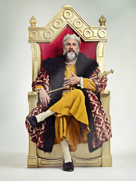 Ich bestieg den Thron friedlich. Studioaufnahme eines reich bekleideten Königs, der auf einem Thron sitzt. — Stockfoto