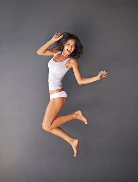 Güzel, mutlu ve sağlıklı. Gri arka planda zıplayan mutlu genç bir kadının tam boy fotoğrafı.. — Stok fotoğraf