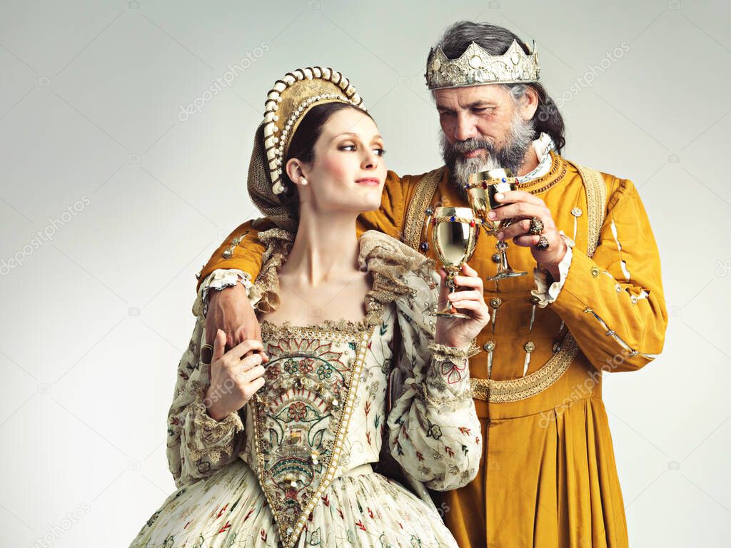 Its good to be royal. Studio shot of a king and queen drinking out of goblets.