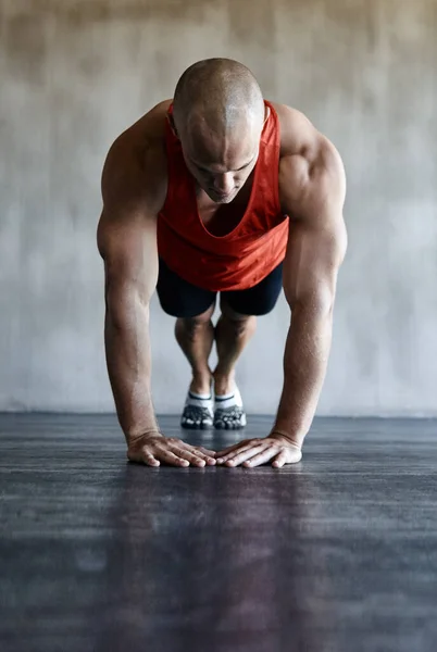 Sich selbst herausfordernd. Aufnahme eines Mannes bei einem herausfordernden Training im Fitnessstudio. — Stockfoto