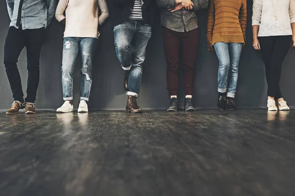 Ponte de moda en tu postura. Captura de estudio de un grupo de personas irreconocibles de pie sobre un fondo gris. —  Fotos de Stock