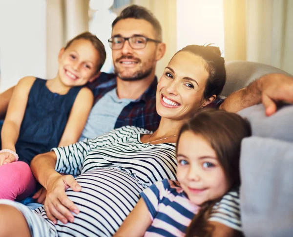 Szczęście to czas dla rodziny. Przycięty portret szczęśliwej młodej rodziny czteroosobowej relaksującej się na kanapie w swoim domu. — Zdjęcie stockowe