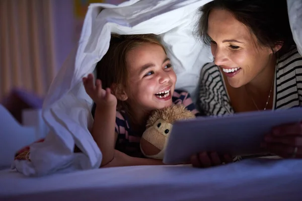 Możemy przeczytać jeszcze jeden, mamo? Ujęcie atrakcyjnej młodej kobiety czytającej córce bajkę na dobranoc. — Zdjęcie stockowe