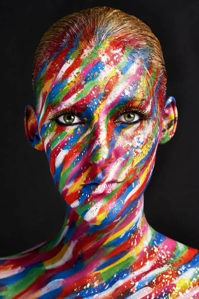 No hay nada aburrido en la belleza. Foto de estudio de una joven posando con pintura de colores brillantes en su cara sobre un fondo negro. —  Fotos de Stock