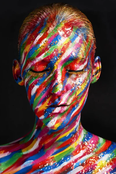 La belleza abraza cada color. Foto de estudio de una joven posando con pintura de colores brillantes en su cara sobre un fondo negro. —  Fotos de Stock