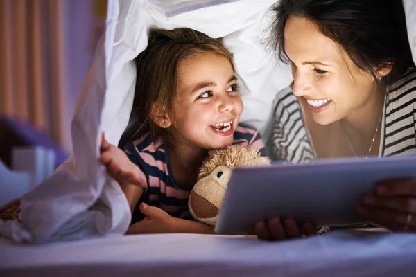 Přečtu si další. Vystřižený záběr atraktivní mladé těhotné ženy čtení její dcery pohádka před spaním na tabletu. — Stock fotografie