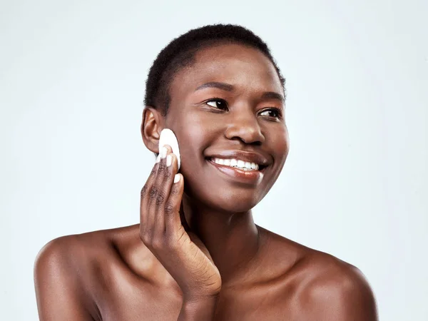 It just melts the makeup away. Studio shot of a beautiful young woman wiping her face with cotton against a grey background. — Stock Photo, Image