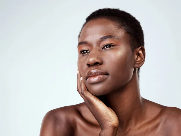 C'est naturel. Plan studio d'une belle jeune femme à la recherche réfléchie sur un fond gris. — Photo