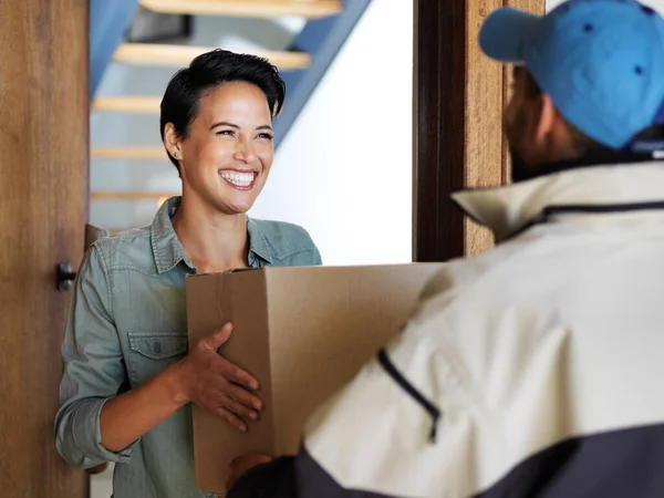 Llegó tan rápido. Fotografía de una joven sonriente parada en la puerta de su casa recibiendo un paquete de un mensajero. —  Fotos de Stock