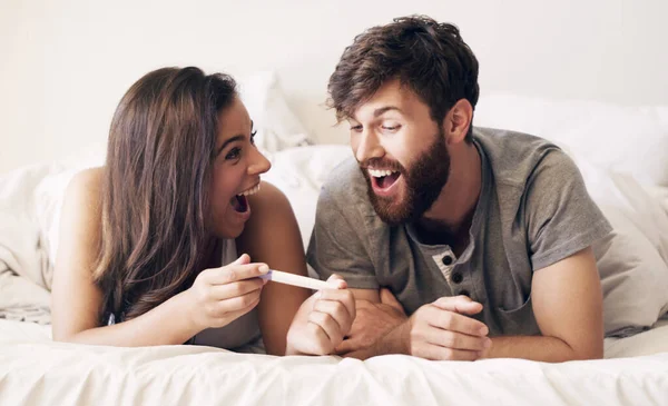 Son esas dos pequeñas líneas. Foto de una feliz pareja joven tomando una prueba de embarazo en casa. — Foto de Stock