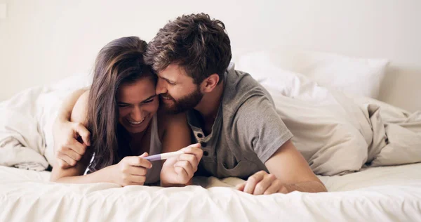 On allait faire de bons parents. Prise de vue d'un jeune couple heureux faisant un test de grossesse à la maison. — Photo