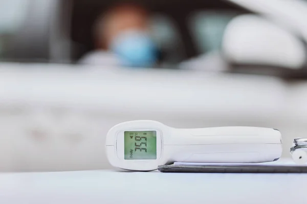 Dont forget to check your temperature. Shot of a thermometer on a table at a drive through vaccination site. — Stock Photo, Image