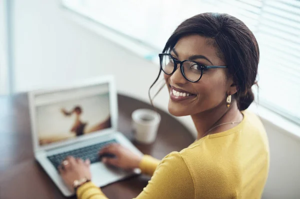 Menyelesaikan posting blog saya. Ditembak seorang wanita muda yang menarik duduk sendirian di rumah dan menggunakan laptopnya. — Stok Foto