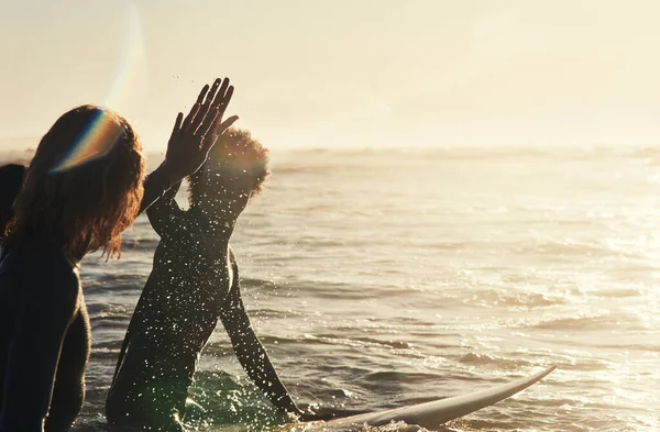 Manteniendo la vibra en marcha. Tiro de un grupo de jóvenes surfistas surfeando juntos en el océano. —  Fotos de Stock