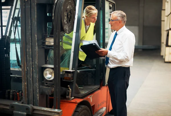 Dinle ve en iyisinden öğren. Forklift kullanan bir çalışana emir veren bir yönetici... — Stok fotoğraf