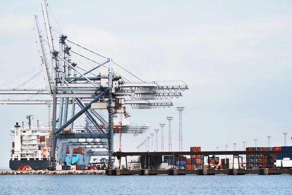 Grúas pórtico en un puerto. Una foto de un puerto con barcos anclados, grúas pórtico y contenedores.. — Foto de Stock