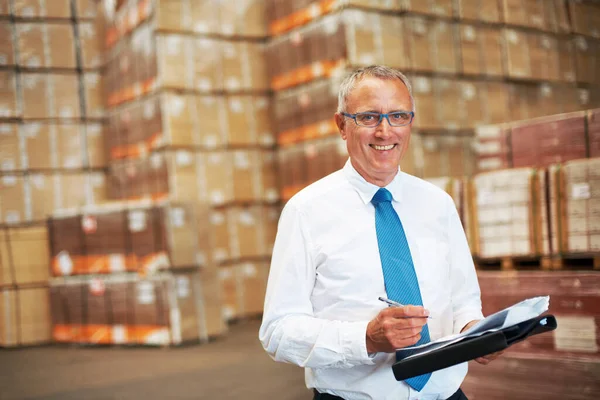 Success is grasping opportunities. A storage warehouse manager standing in the factor amidst many boxes. — Stock Photo, Image
