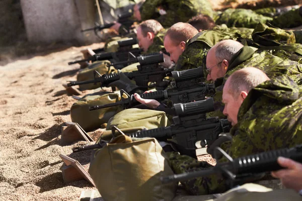 Навчання гострих стрільців. Лінія солдатів, що лежать і прицілюються зі зброєю . — стокове фото
