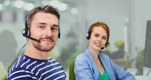 Wie können wir etwas bewirken? Porträt zweier Geschäftskollegen mit Headsets im Büro. — Stockfoto