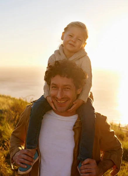 Os pais têm a boleia coberta. Retrato de um pai dando a sua menina um passeio em seus ombros, enquanto em um passeio na natureza. — Fotografia de Stock