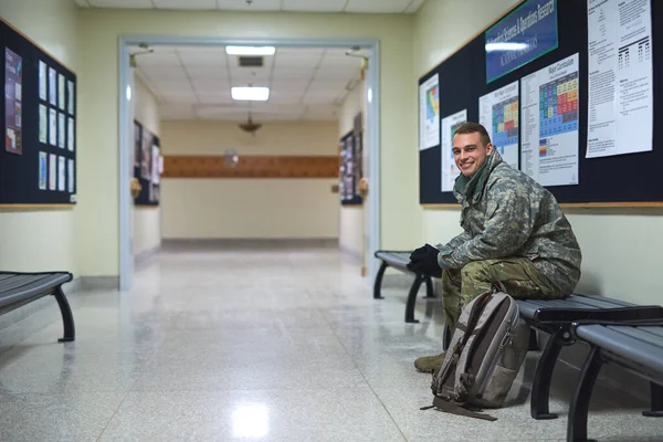 Donde nacen los héroes. Disparo de un joven soldado sentado en un banco en el pasillo de una academia militar. — Foto de Stock