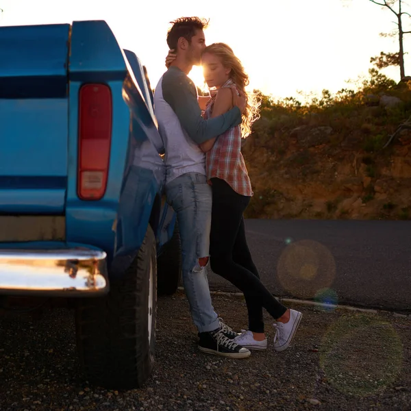 Romance fuera de la carretera. Foto de una pareja joven y cariñosa en un viaje por carretera. —  Fotos de Stock