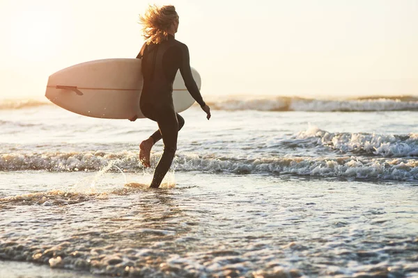 Uwolnij się od świata. Zdjęcie z tyłu młodego mężczyzny surfującego na plaży. — Zdjęcie stockowe