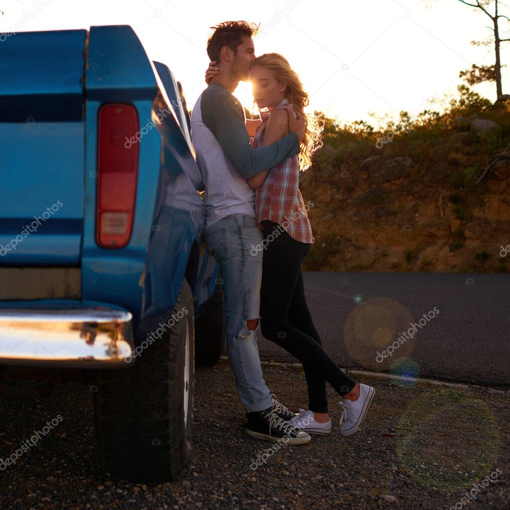 Off road romance. Shot of an affectionate young couple on a roadtrip.