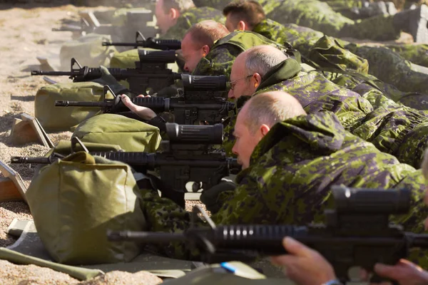 Підготовка до війни. Постріл групи солдатів, які прицілюються до своїх гвинтівок, лежачи на землі . — стокове фото