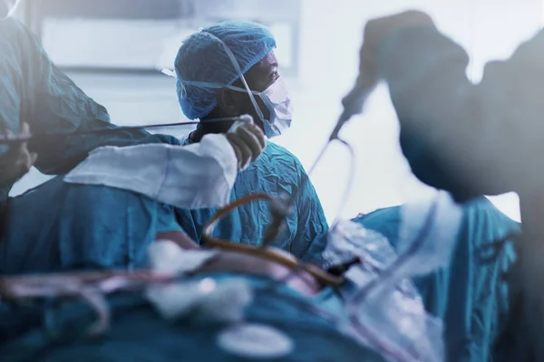 Встановлення стандарту хірургічного вдосконалення. Постріл відданої команди молодих хірургів, які виконують операцію на пацієнта в операційній кімнаті . — стокове фото