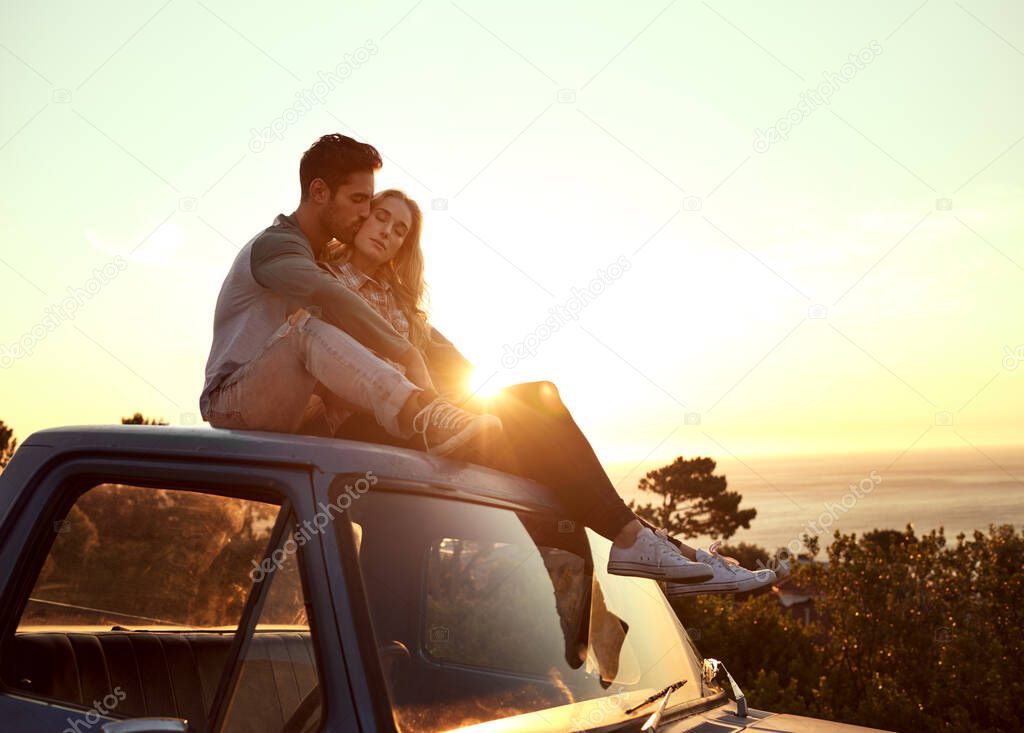 Romance on the road. Shot of an affectionate young couple enjoying a roadtrip together.