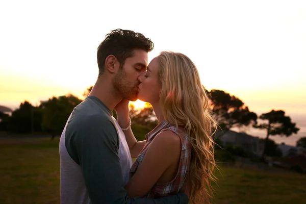 Smooches au coucher du soleil. Plan recadré d'un jeune couple affectueux à l'extérieur. — Photo