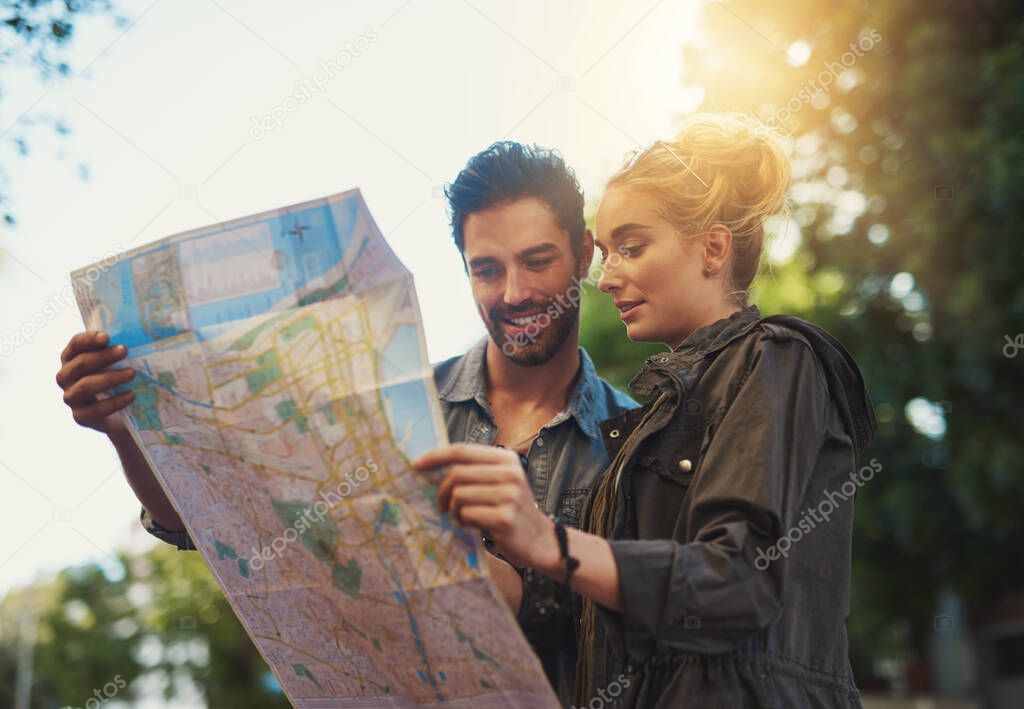 Enjoy the journey. Shot of a young couple using a map while exploring the city.