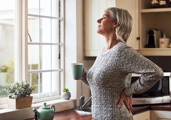 Already feeling better. Cropped shot of a relaxed senior woman preparing a cup of tea with CBD oil inside of it at home during the day. — Stock Photo, Image