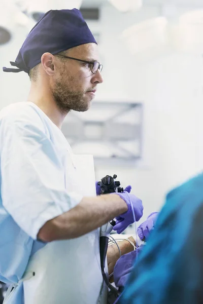 Salvar vidas é o que ele faz. Tiro de um jovem cirurgião realizando cirurgia em um paciente em uma sala de cirurgia. — Fotografia de Stock