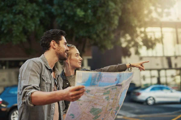 Lasciate che la curiosità faccia strada. Girato di una giovane coppia utilizzando una mappa durante l'esplorazione della città. — Foto Stock