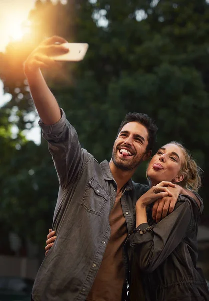 Ci piace fare selfie. Girato di una giovane coppia che si fa un selfie in città. — Foto Stock