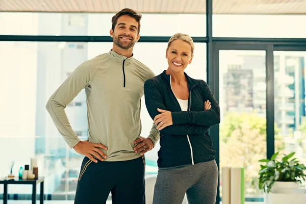 Přátelský fitness fond. Portrét dvou šťastných fyzioterapeutů pózujících společně ve fitness centru. — Stock fotografie
