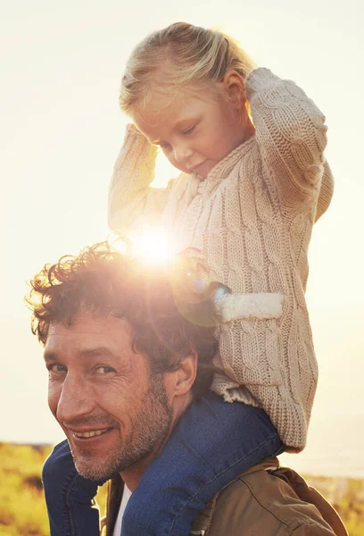 Eles divertem-se mais juntos. Tiro de um pai carregando sua menina em seus ombros enquanto caminhava ao ar livre. — Fotografia de Stock