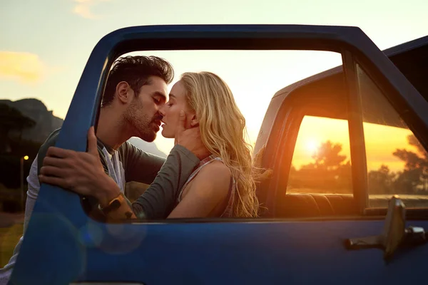 Hans kyss henger igjen på hennes lepper. Skutt av et kjærlig ungt par på en kjøretur. stockbilde