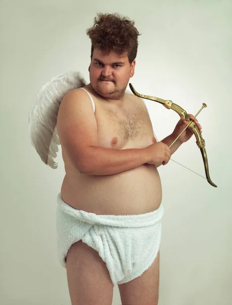 Er bringt die Liebe zu diesem Valentinstag. Ein fettleibiger Mann als Cherub verkleidet, während er isoliert ist. — Stockfoto