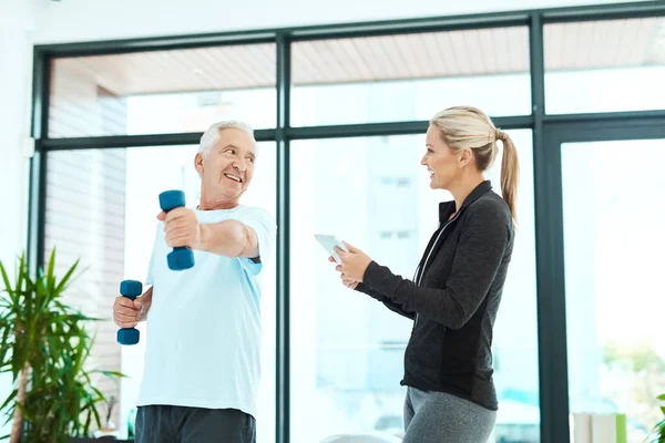 Le vagyok nyűgözve a fejlődésétől. Lelőttek egy fizioterapeutát, aki segített az idősebb betegének a gyakorlatában egy fitneszteremben.. — Stock Fotó