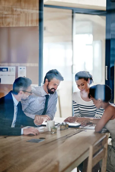 Empezar a trabajar con la tecnología. Fotografía de un grupo de colegas que utilizan una tableta digital juntos mientras trabajan alrededor de una mesa en una oficina. — Foto de Stock