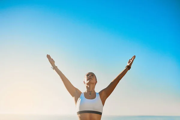 Invierte tu energía en el presente. Foto de una joven atlética practicando yoga en la playa. — Foto de Stock