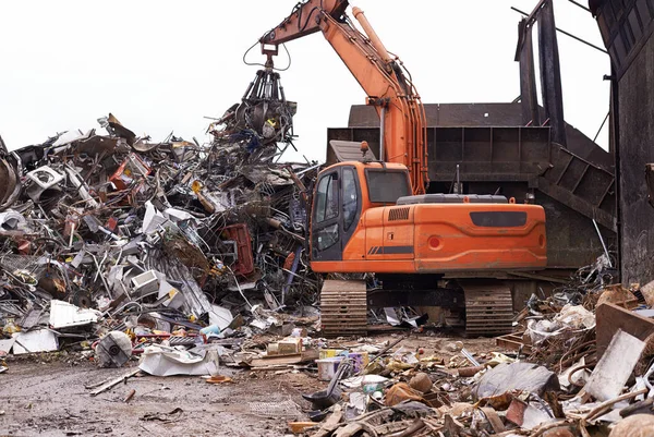 废品场挖掘机在一堆废金属中分拣的截图. — 图库照片