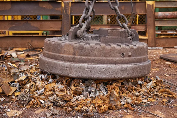 Outils du commerce de la ferraille. Un grand aimant ramasse les ordures dans un trashyard. — Photo