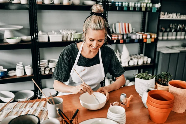 Es hora de pintar. Recortado disparo de una atractiva mujer madura sentada sola y pintando un tazón de cerámica en su estudio. — Foto de Stock